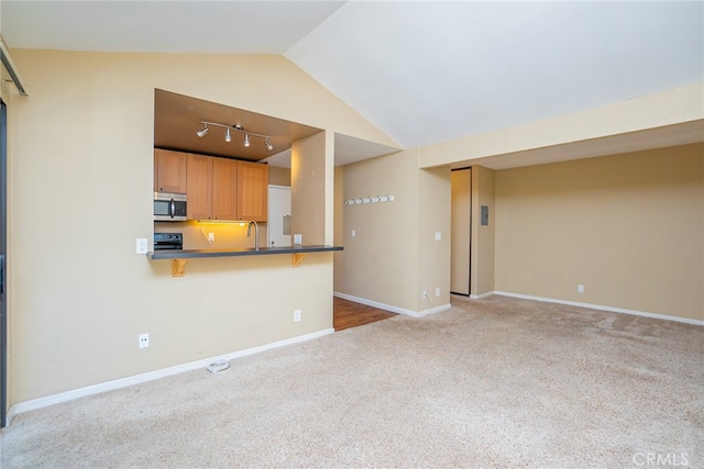 unfurnished living room featuring vaulted ceiling, light carpet, and track lighting