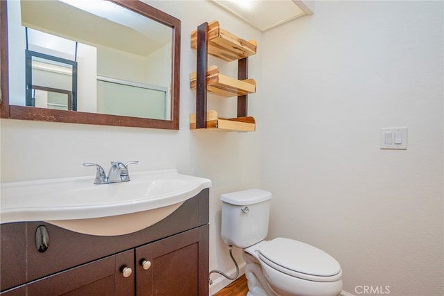 bathroom with vanity, toilet, and hardwood / wood-style flooring