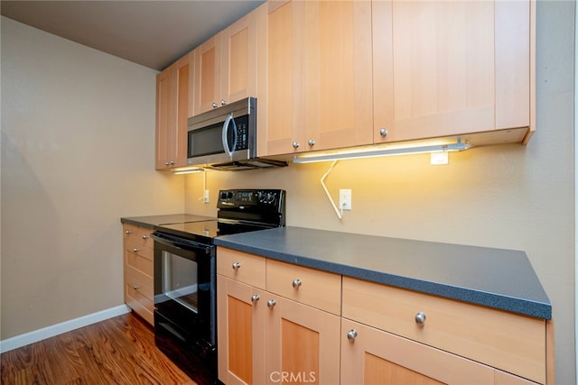 kitchen with black range with electric stovetop, light brown cabinets, and dark hardwood / wood-style floors