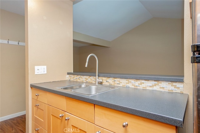 kitchen with decorative backsplash, lofted ceiling, hardwood / wood-style floors, and sink