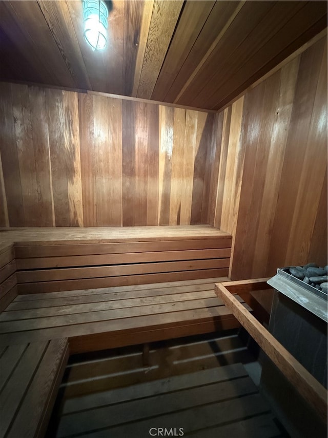 view of sauna featuring wooden walls and wooden ceiling