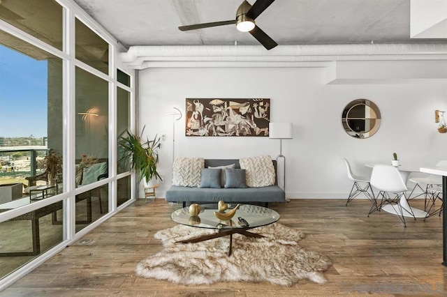 sitting room featuring ceiling fan, hardwood / wood-style flooring, and a wall of windows