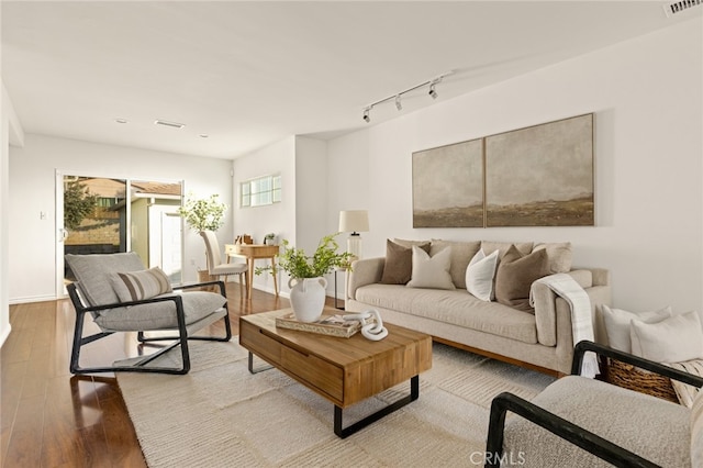 living room with hardwood / wood-style flooring and track lighting