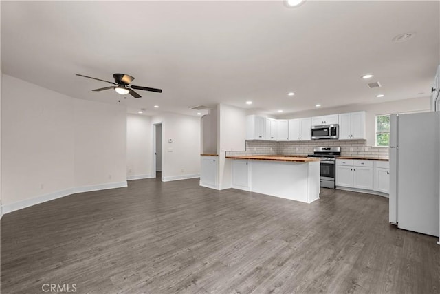 kitchen featuring ceiling fan, hardwood / wood-style floors, stainless steel appliances, white cabinets, and butcher block counters