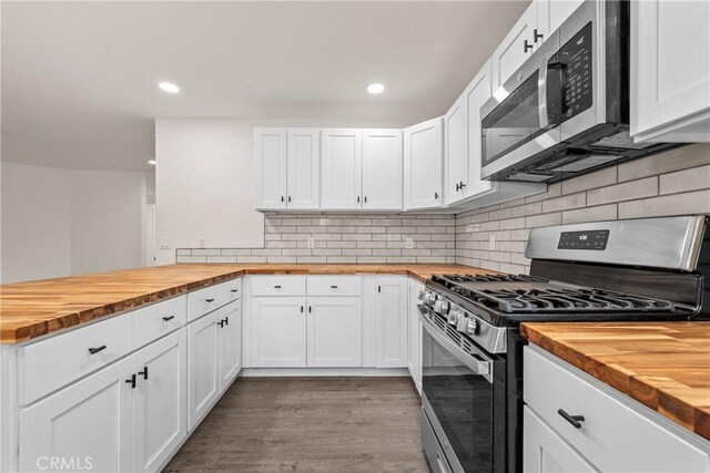 kitchen featuring butcher block countertops, stainless steel appliances, decorative backsplash, dark hardwood / wood-style floors, and white cabinets