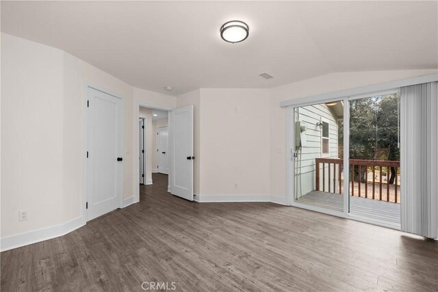 unfurnished room with lofted ceiling and hardwood / wood-style floors