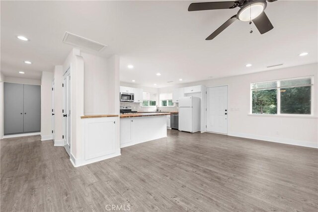 kitchen with ceiling fan, light wood-type flooring, stainless steel appliances, white cabinets, and wood counters