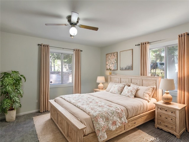 carpeted bedroom featuring multiple windows and ceiling fan