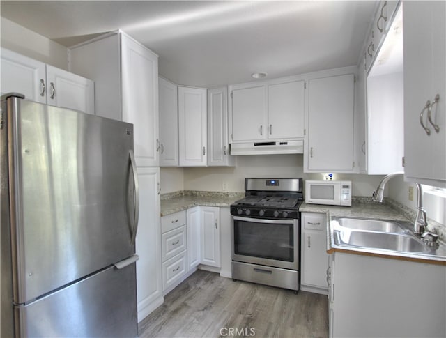 kitchen featuring white cabinets, stainless steel appliances, light wood-type flooring, and sink