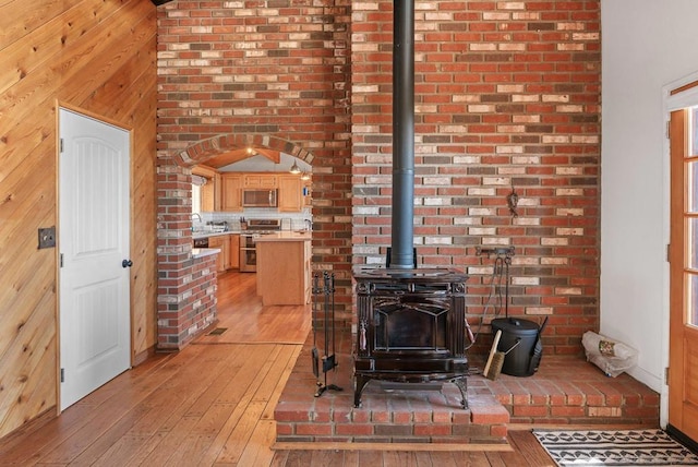 living room featuring light wood-type flooring and wood walls