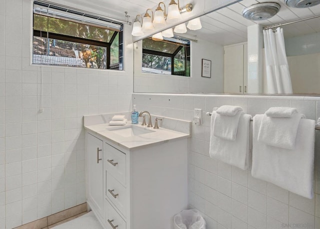 bathroom featuring a shower with shower curtain, tile walls, and vanity