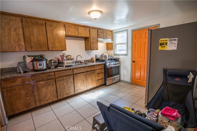 kitchen with light tile patterned flooring, stainless steel appliances, and sink