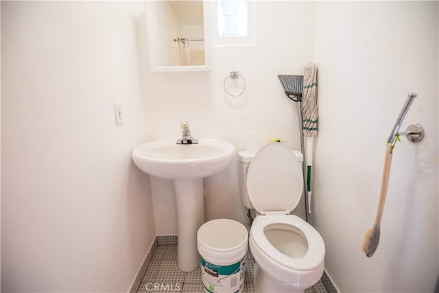 bathroom with toilet and tile patterned floors