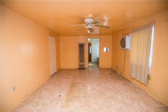 unfurnished room featuring ceiling fan and a wall mounted air conditioner