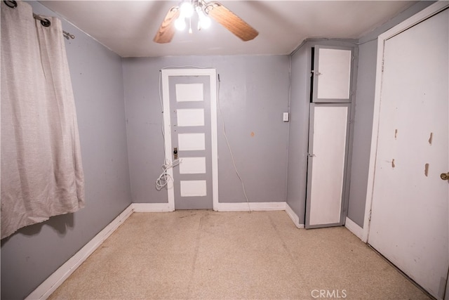 carpeted foyer entrance featuring ceiling fan