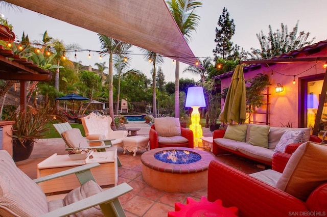 view of patio with an outdoor living space with a fire pit