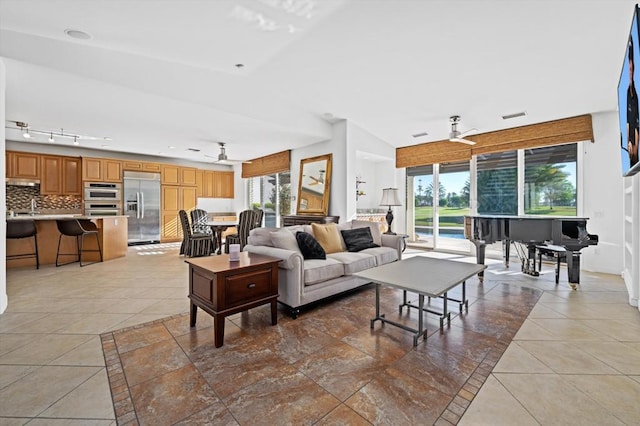 living room featuring tile patterned floors, ceiling fan, and sink