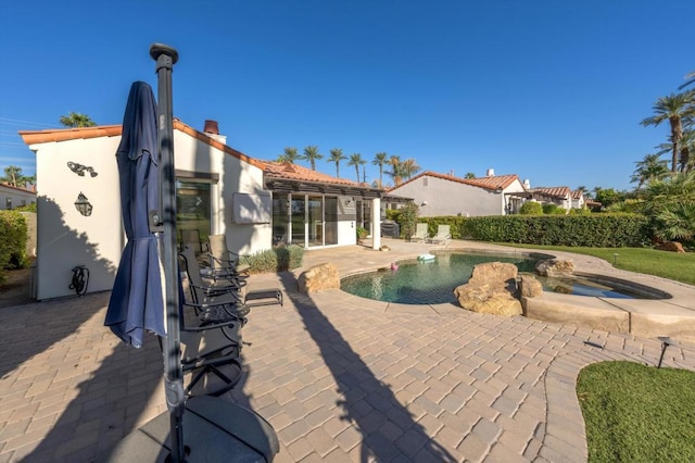 view of pool with an in ground hot tub and a patio