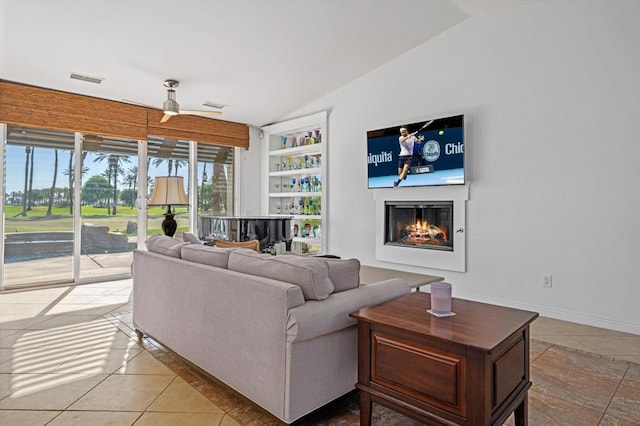 living room with ceiling fan, light tile patterned flooring, and vaulted ceiling