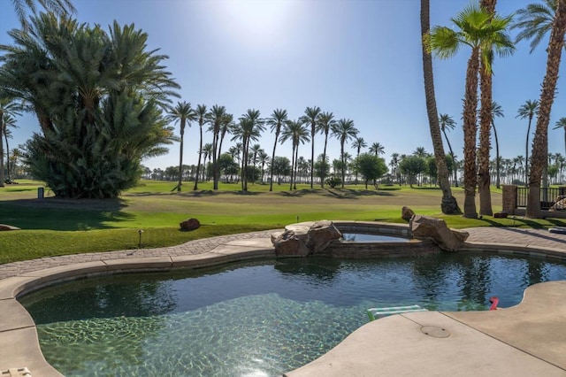 view of pool featuring a yard and an in ground hot tub