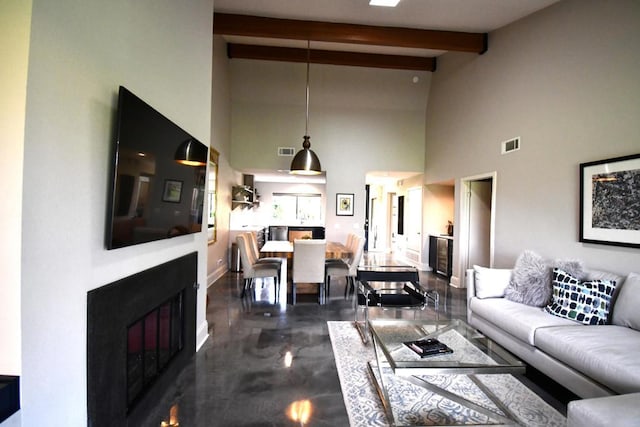 living room with beam ceiling and high vaulted ceiling