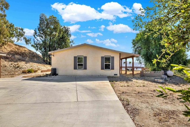 view of side of home featuring a deck and a patio area