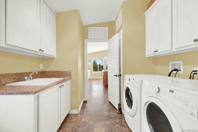 laundry room featuring separate washer and dryer, sink, and cabinets