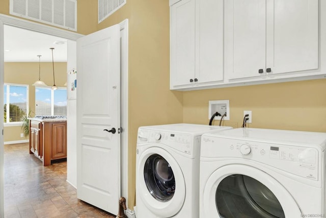 laundry area featuring washer and dryer and cabinets