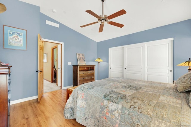 bedroom featuring ceiling fan, vaulted ceiling, a closet, and light hardwood / wood-style floors