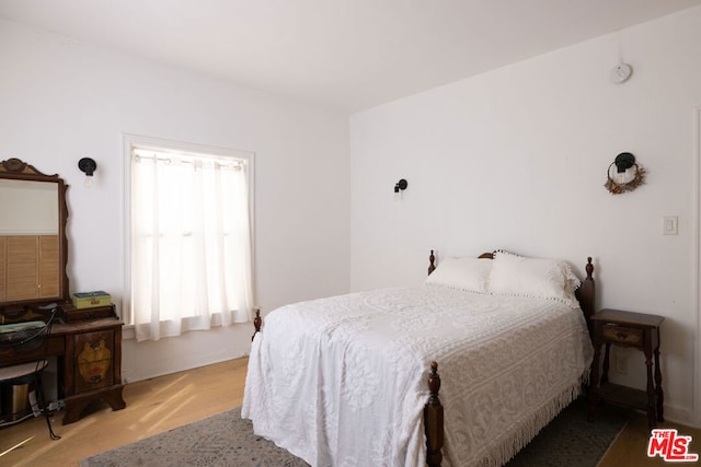 bedroom with hardwood / wood-style floors and multiple windows