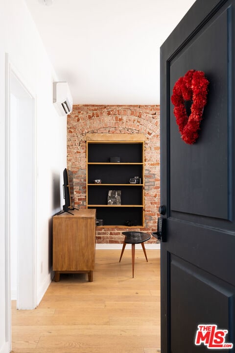 bar with brick wall, wood-type flooring, and a wall unit AC