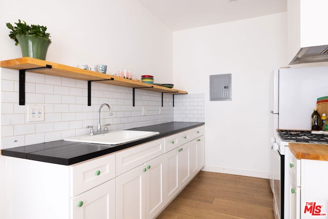 kitchen with white appliances, electric panel, white cabinets, sink, and light wood-type flooring