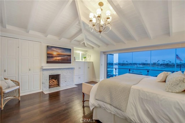 bedroom with an inviting chandelier, vaulted ceiling with beams, a high end fireplace, access to outside, and hardwood / wood-style flooring