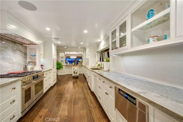 kitchen featuring light stone countertops, backsplash, white cabinetry, and stainless steel appliances