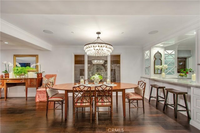 dining area featuring ornamental molding, dark wood-type flooring, and an inviting chandelier