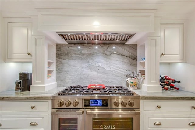 kitchen with white cabinets, double oven range, premium range hood, and light stone counters