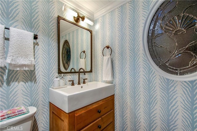 bathroom with toilet, vanity, and ornamental molding