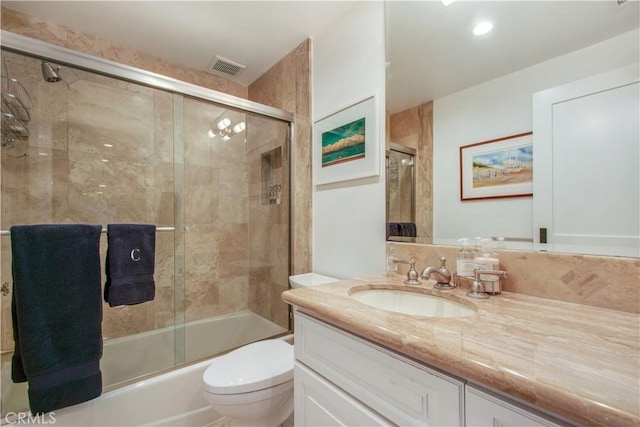 full bathroom with shower / bath combination with glass door, vanity, and toilet