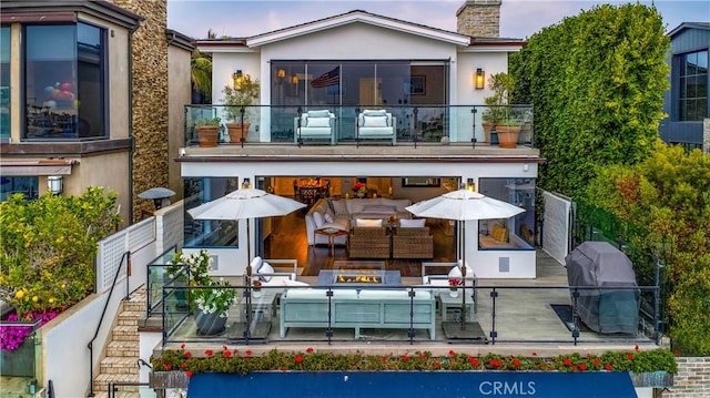 back of house with outdoor lounge area and a balcony