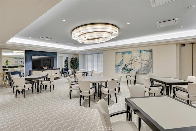 dining area featuring a raised ceiling, light carpet, and visible vents