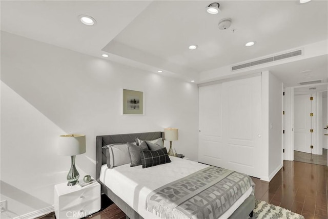 bedroom featuring dark wood-type flooring, recessed lighting, a closet, and visible vents