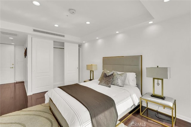 bedroom featuring recessed lighting, a closet, visible vents, and wood finished floors