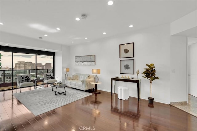 living room featuring baseboards, wood finished floors, and recessed lighting