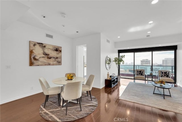 dining room with baseboards, visible vents, wood finished floors, and recessed lighting