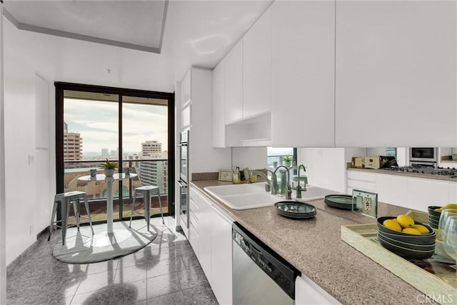 kitchen featuring stainless steel appliances, white cabinetry, and a sink