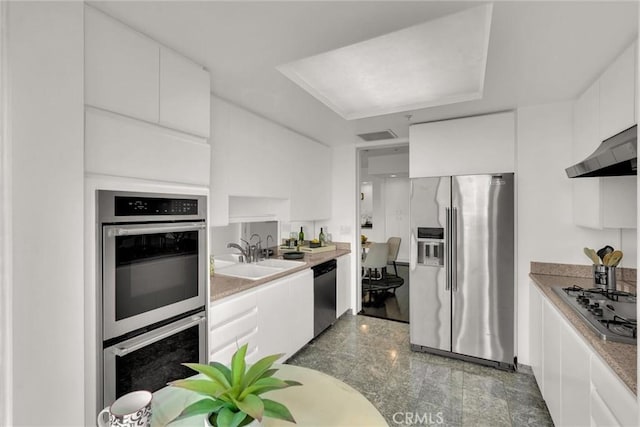 kitchen featuring extractor fan, granite finish floor, a sink, white cabinetry, and appliances with stainless steel finishes