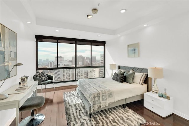 bedroom featuring a city view, wood finished floors, and recessed lighting