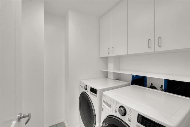 laundry area featuring washing machine and dryer and cabinet space