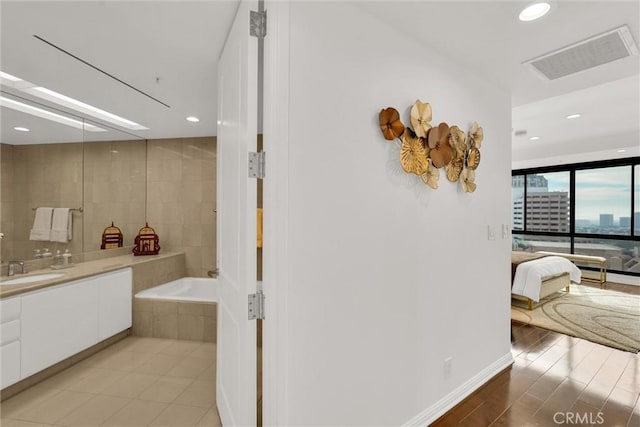 full bath with vanity, visible vents, tile patterned floors, tiled tub, and ensuite bath