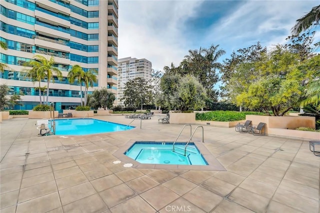 pool featuring a hot tub and a patio